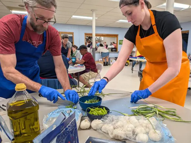 Aaron Ramsey and Julia Sonntag prepare garlic scape pesto at a food preservation and canning event on June 11, 2026 in Des Moines.