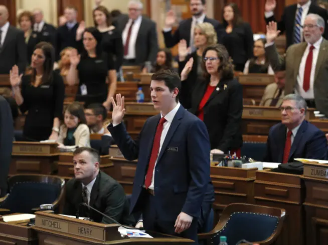 Rep. Joe Mitchell, R-Wayland, center, takes the oath of office during the opening day of the Iowa Legislature, Monday, Jan. 14, 2019, at the Statehouse in Des Moines, Iowa.